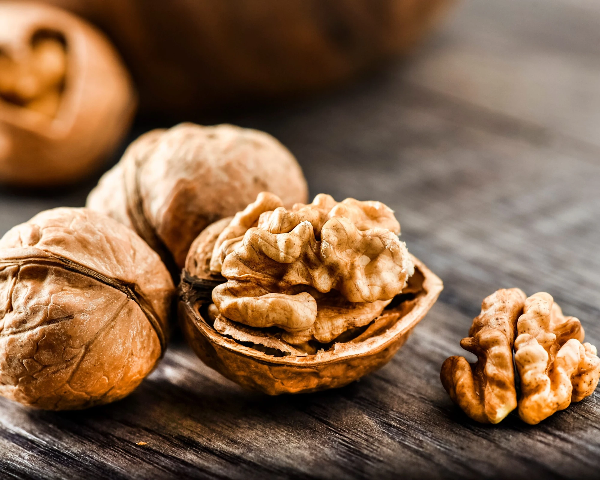 Walnuts in shell with a cracked walnut and kernels